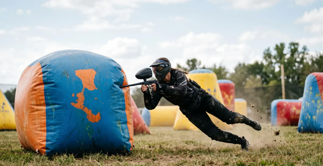 Joueurs de paintball en pleine action sur un terrain rempli d'obstacles gonflables colorés