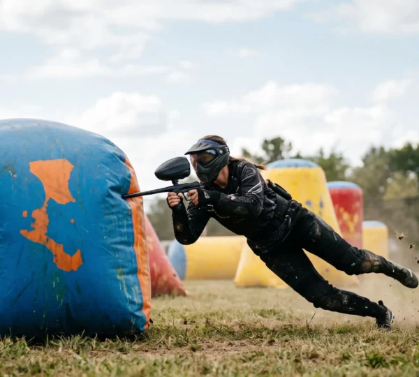 Joueurs de paintball en pleine action sur un terrain rempli d'obstacles gonflables colorés